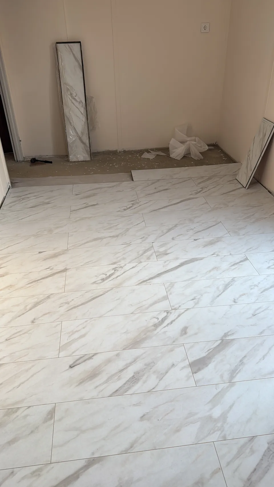 Heller Boden in Marmoroptik, mit Material an der Wand